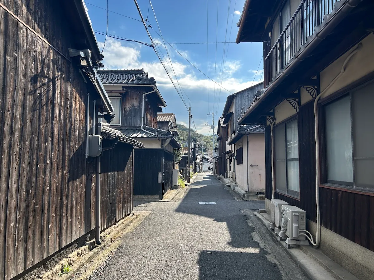 本村地区の細い路地に並ぶ焼杉板の民家